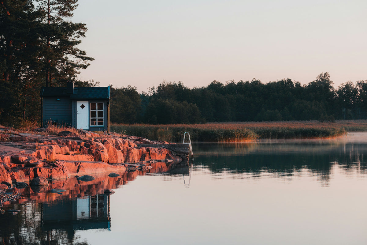 Red cabin on a rocky shore at dusk, Åland Islands