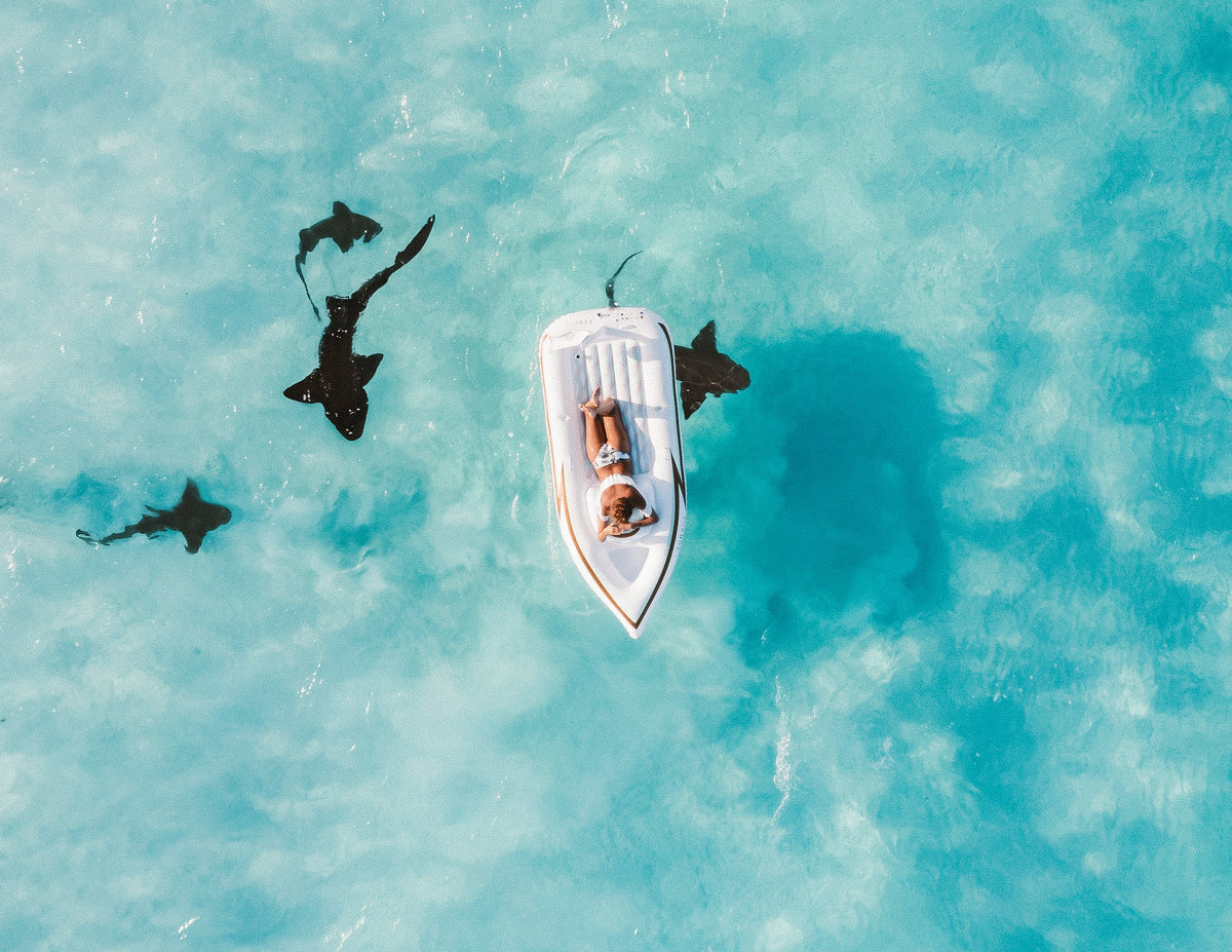 Boat in shallow turquoise water from above, Bahamas