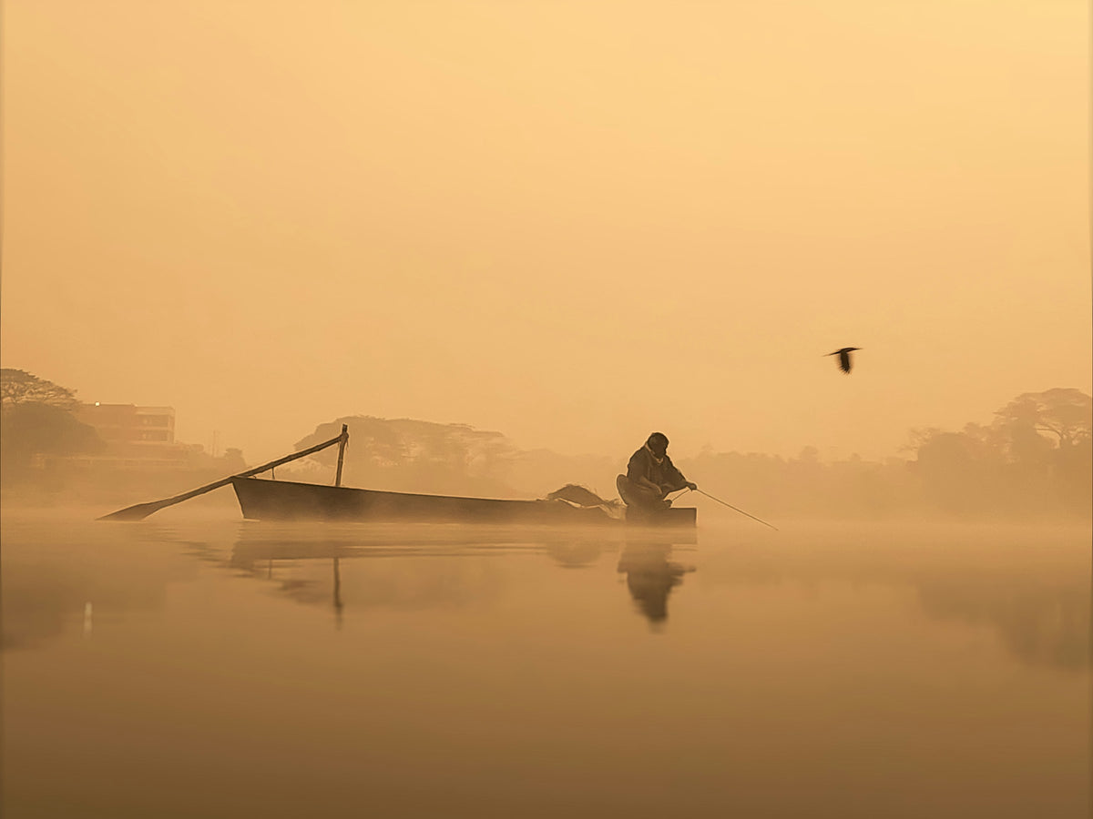 Boat on a misty river at sunrise, Bangladesh