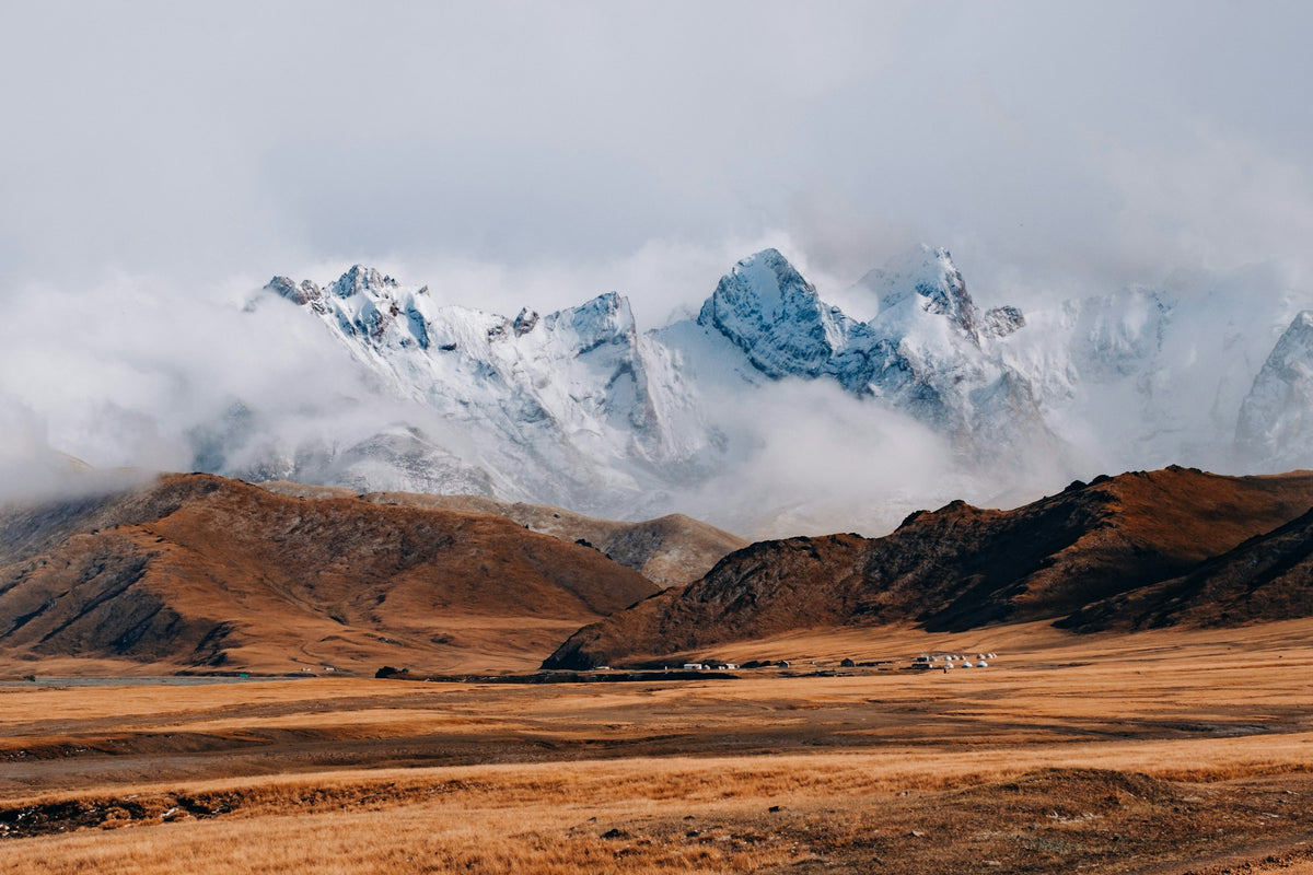 Snowy peaks above red hills, Kyrgyzstan