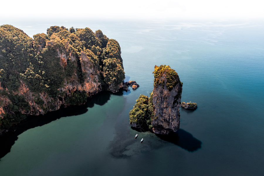 Limestone cliffs and a rock pinnacle in calm water near Krabi, seen from above