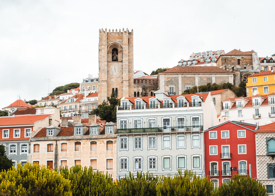 The bell tower of Lisbon Cathedral above colourful houses in Alfama, Lisbon