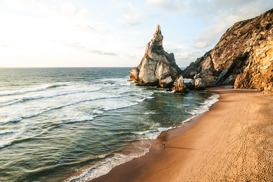 Rock pinnacles and a sandy beach below steep cliffs at Praia da Ursa