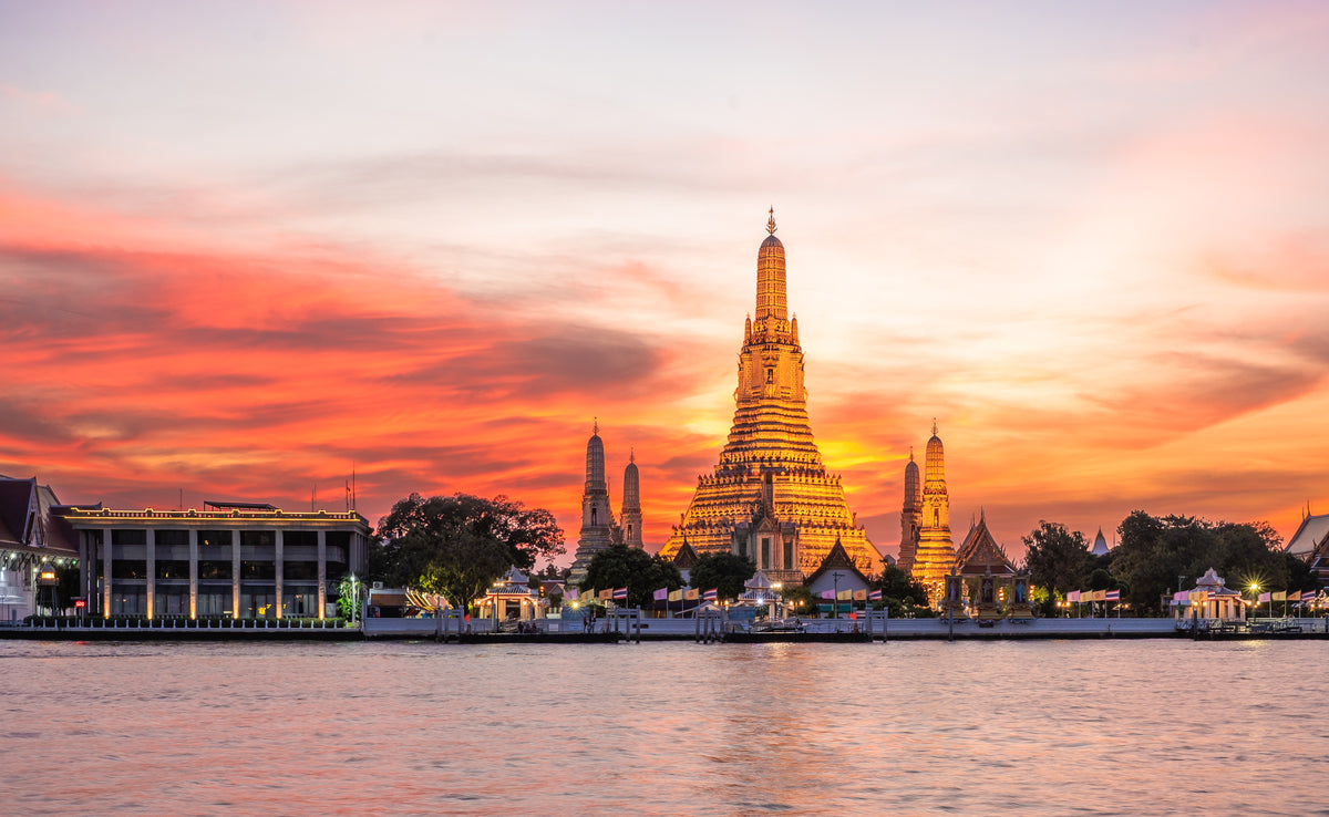 Wat Arun lit up at sunset across the Chao Phraya River in Bangkok