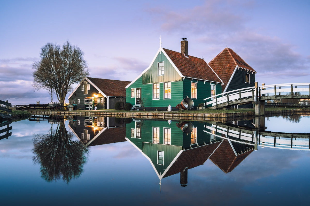 Green wooden houses reflected in the water at Zaanse Schans, Netherlands