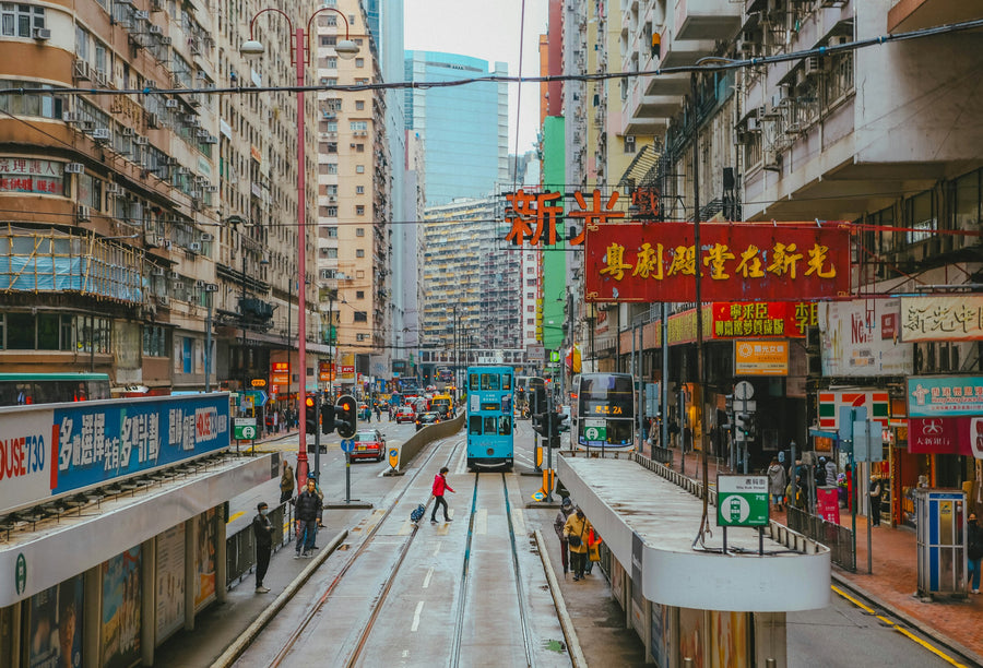 Een tram in een drukke straat vol uithangborden op Hong Kong Island