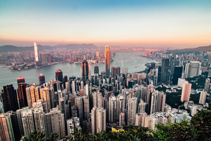 Uitzicht over de wolkenkrabbers en de haven van Hongkong vanaf Victoria Peak bij zonsondergang