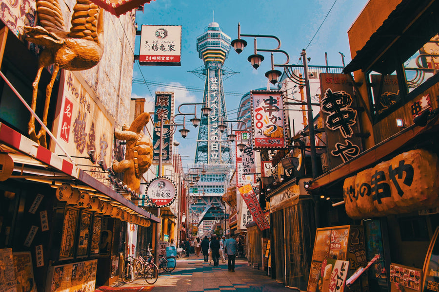 Shop signs in the Shinsekai district of Osaka with Tsutenkaku tower behind