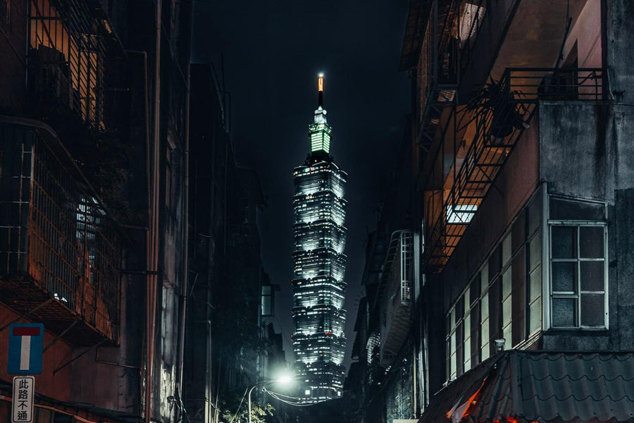 Taipei 101 lit up at night at the end of a narrow street in Taipei, Taiwan