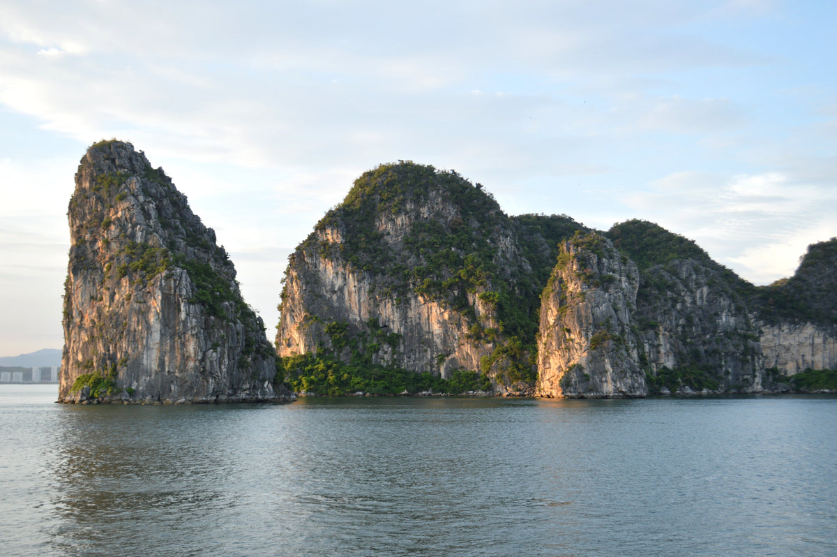 Limestone cliffs rising from calm water in Ha Long Bay